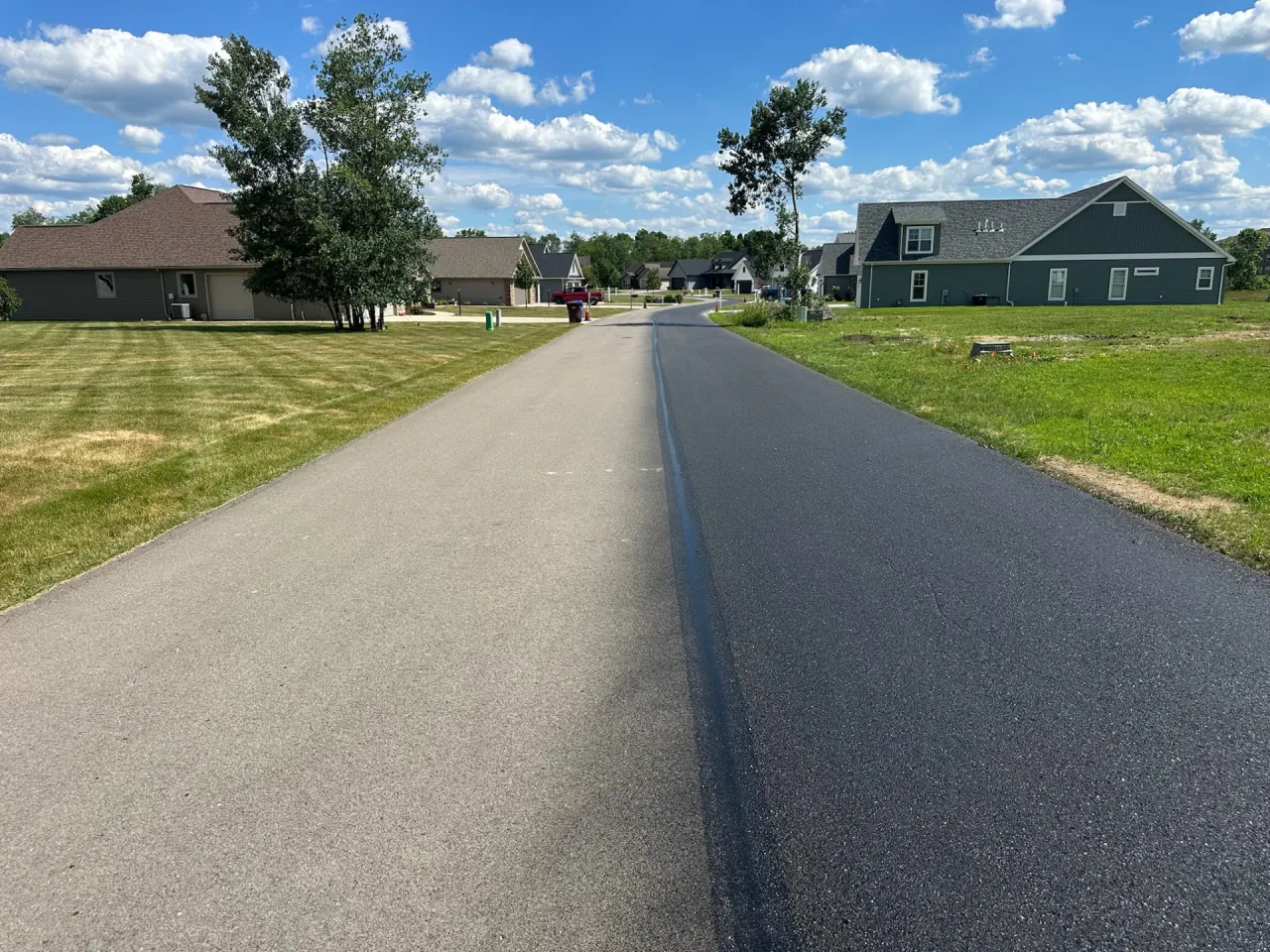 Continuous roadway showing existing pavement beside RevivaRoad-treated pavement